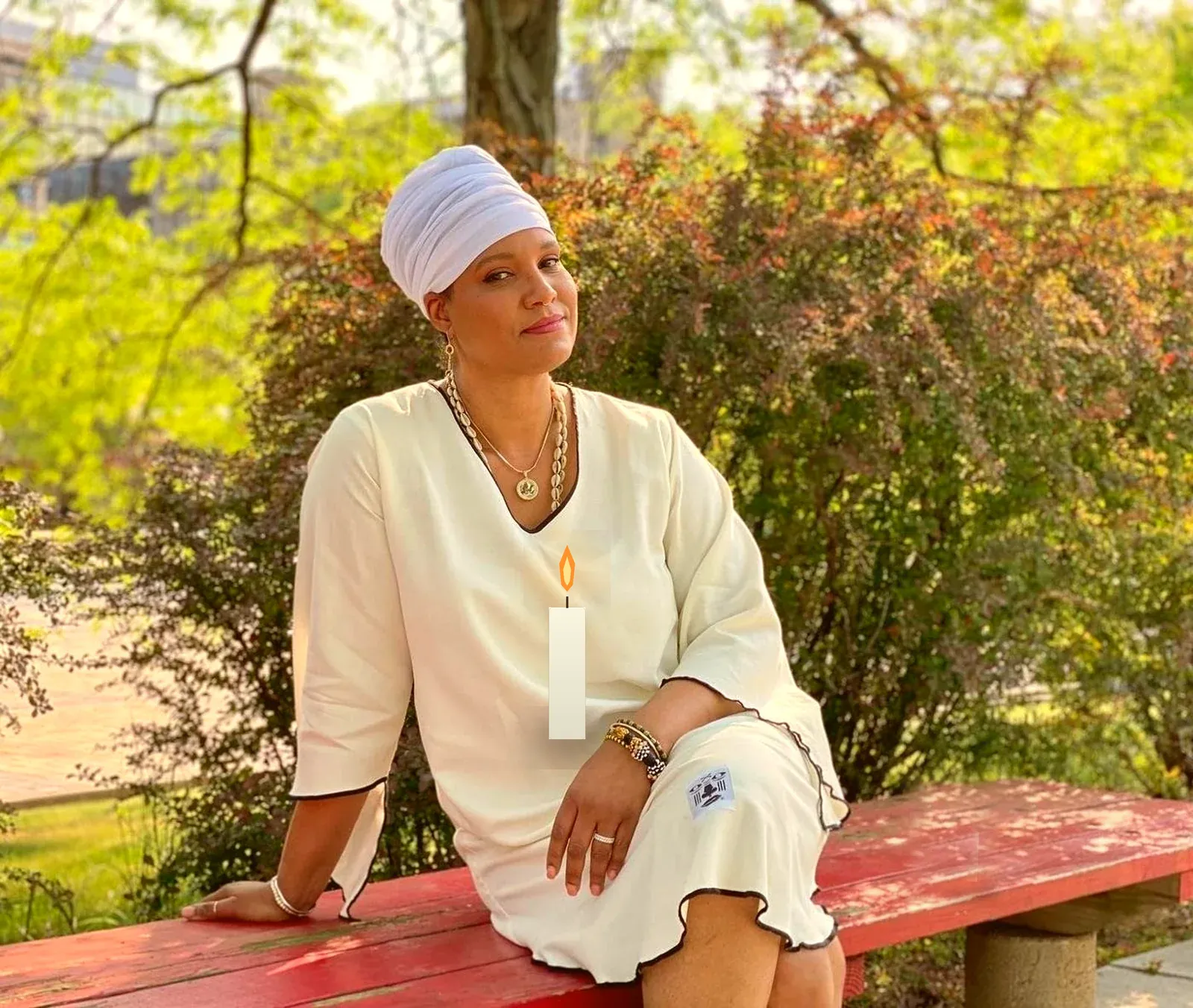 Rev. Dr. Elemi Gayle at a warm-lit table, a candle burning beside her